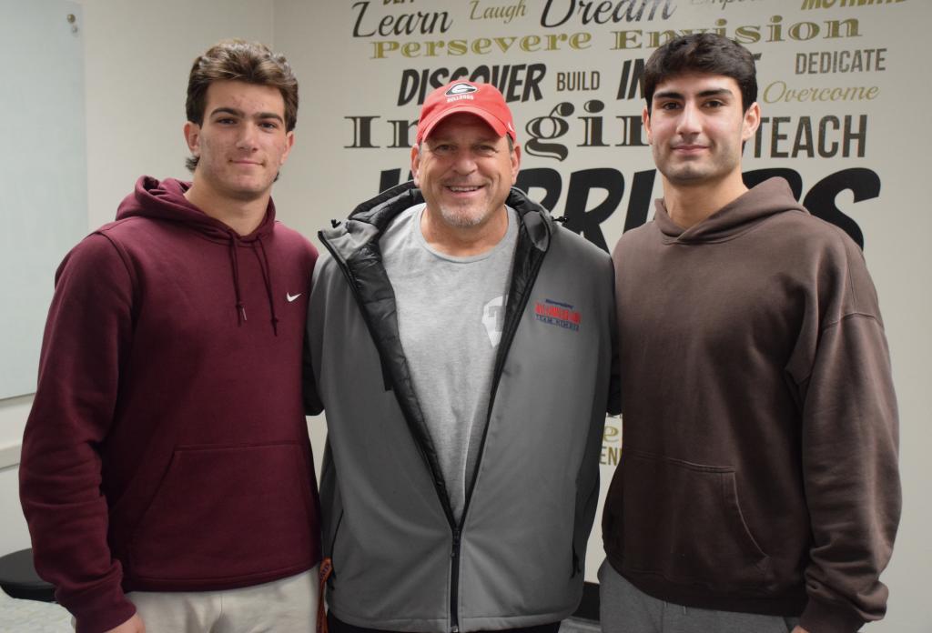 two football players stand by coach